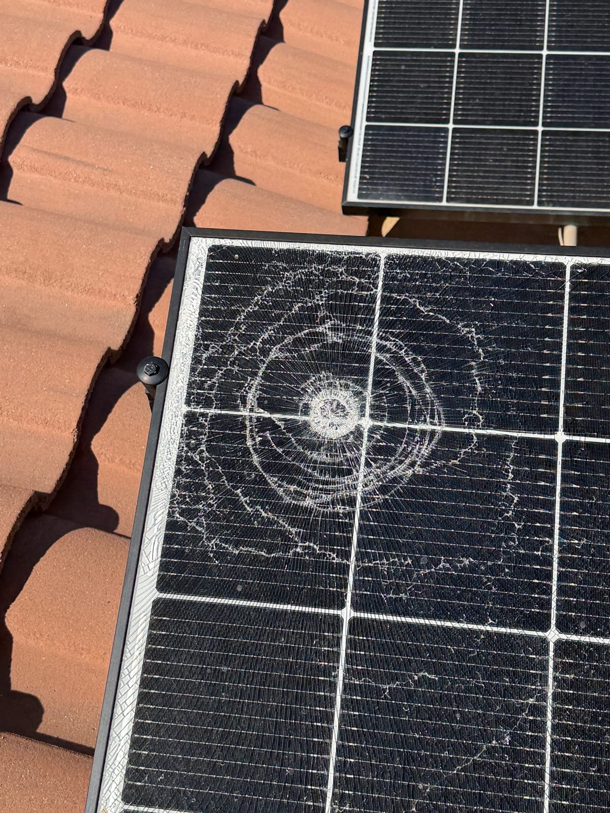 Shattered solar panel on a tile roof