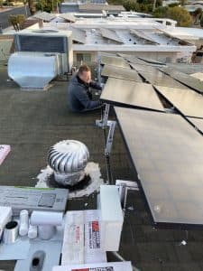 SolarFIX crew removing solar panels from a roof
